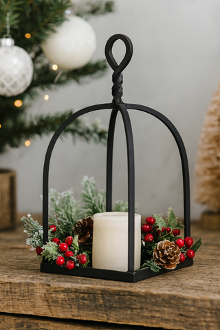 Decorative lantern with a candle, surrounded by festive elements on a wooden surface.