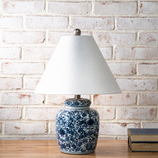Decorative lamp with blue floral pattern on a white brick wall background