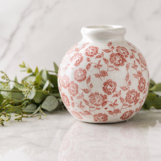 White vase with red floral pattern on a light background