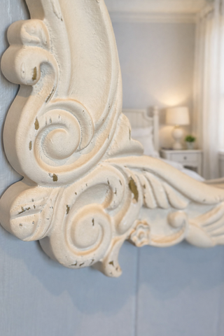 Decorative mirror with intricate carvings in a bedroom setting