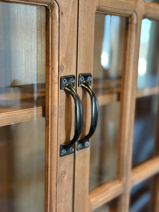 Wooden cabinet with glass doors and black metal handles