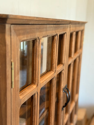 Wooden cabinet with glass panels and a handle on a blurred background